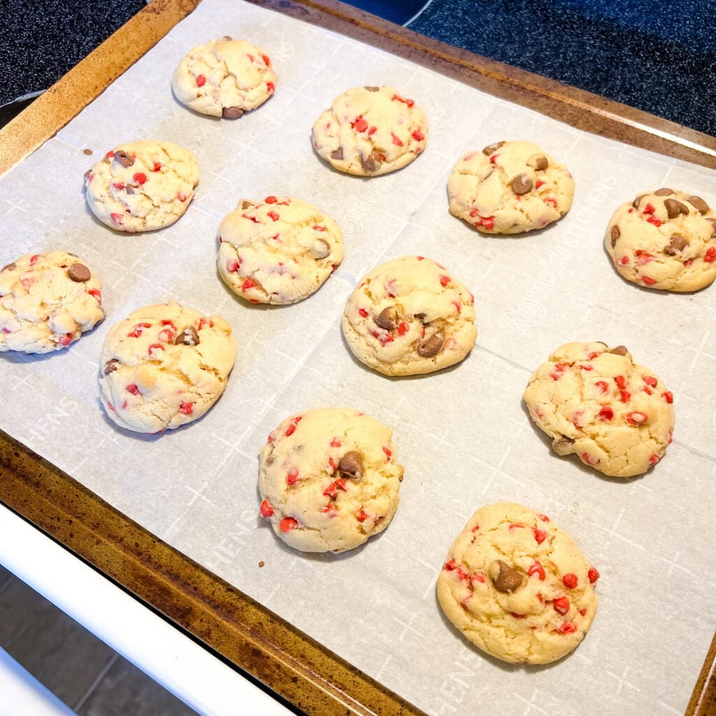 Freshly baked chocolate cherry chip cookies on a baking sheet.