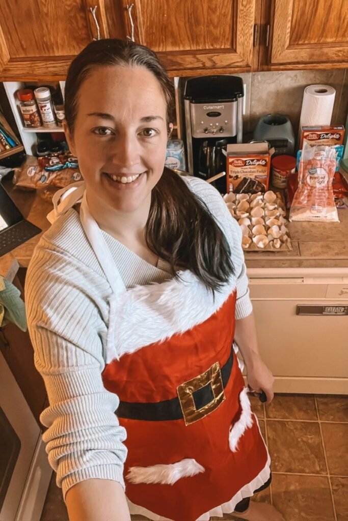 Baking in the kitchen wearing a Mrs. Claus apron.