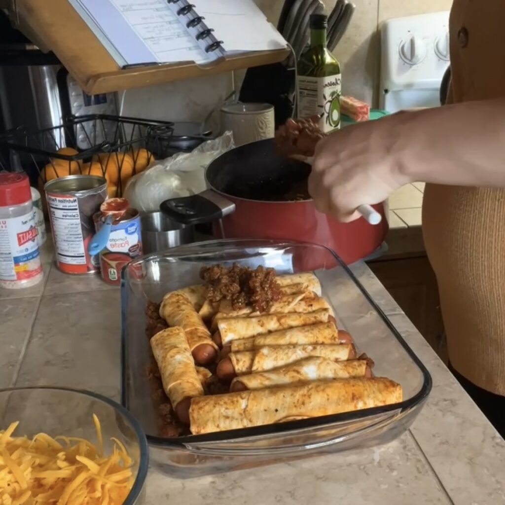 Covering the Egglife wrapped hot dogs with chili to make a yummy keto chili cheese dog casserole.