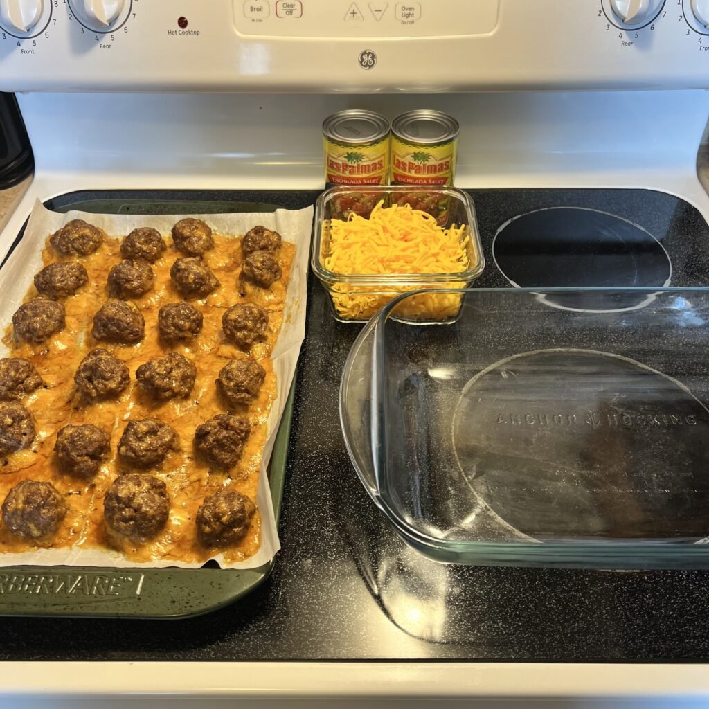 Ingredients and baking dishes needed to make a cheesy keto enchilada meatball bake.