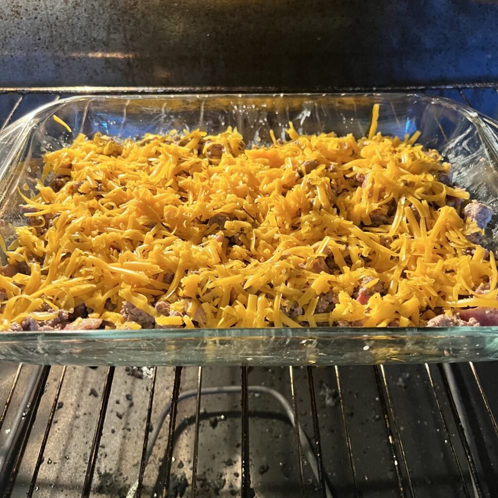 A cheesy bacon and beef carnivore casserole baking in the oven.