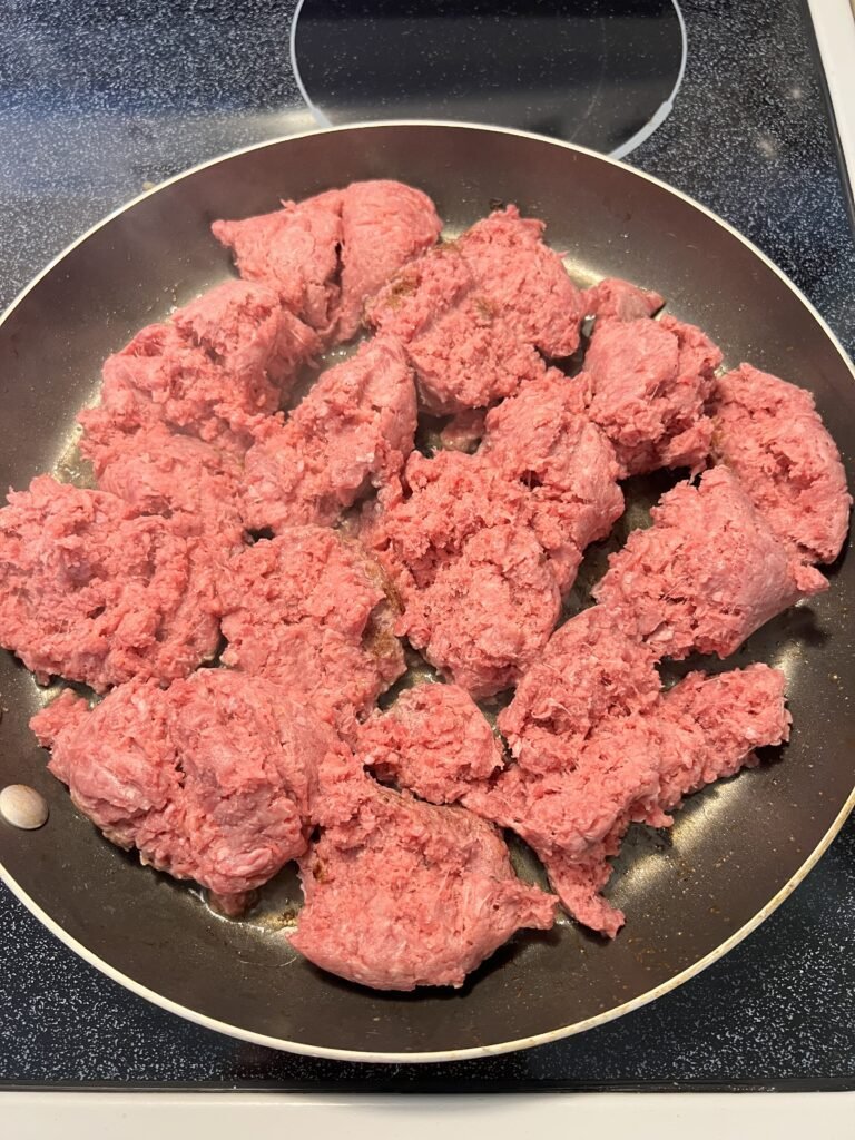 Browning ground beef in a frying pan for a yummy keto beef stroganoff.