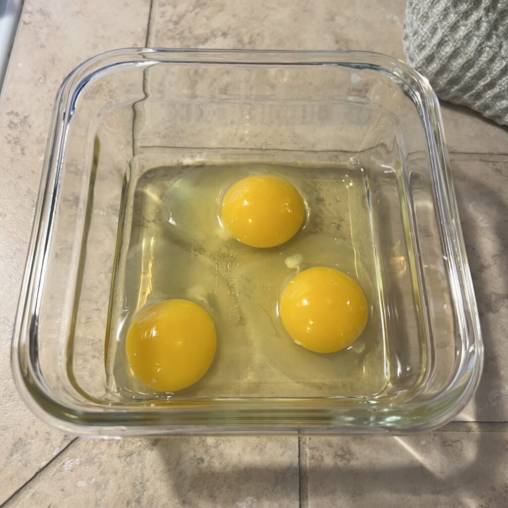 Cracked eggs in a bowl that will go in a delicious carnivore casserole.
