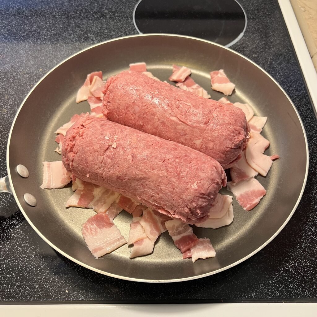 Frying bacon and ground beef in a skillet.