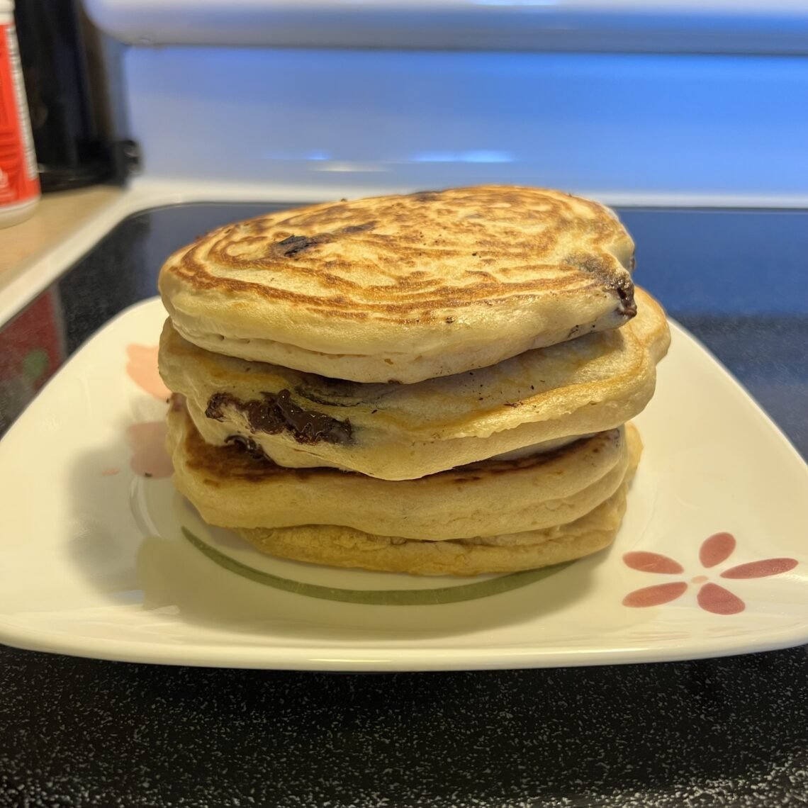 A stack of fluffy sourdough discard pancakes with rich Ghirardelli chocolate chips