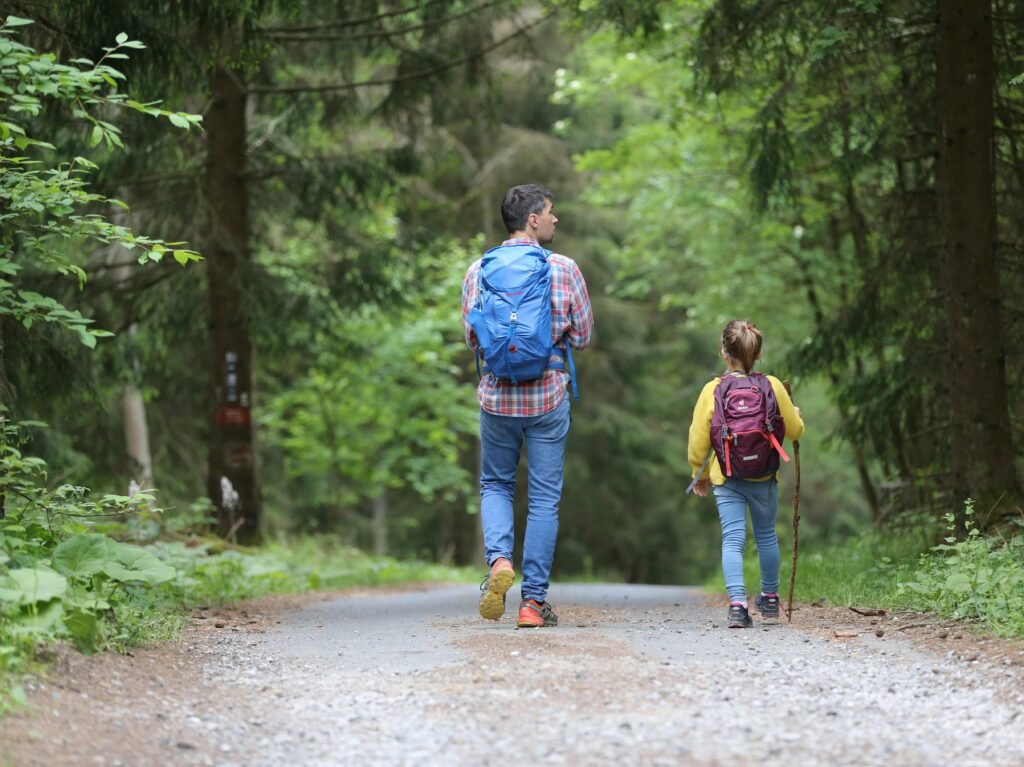 A father and his daughter hiking in the great outdoors.