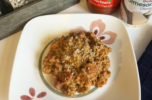 An overhead shot of a plate of creamy ground beef with tomatoes and marinara. Served with grated parmesan cheese for a simple and hearty family dinner.