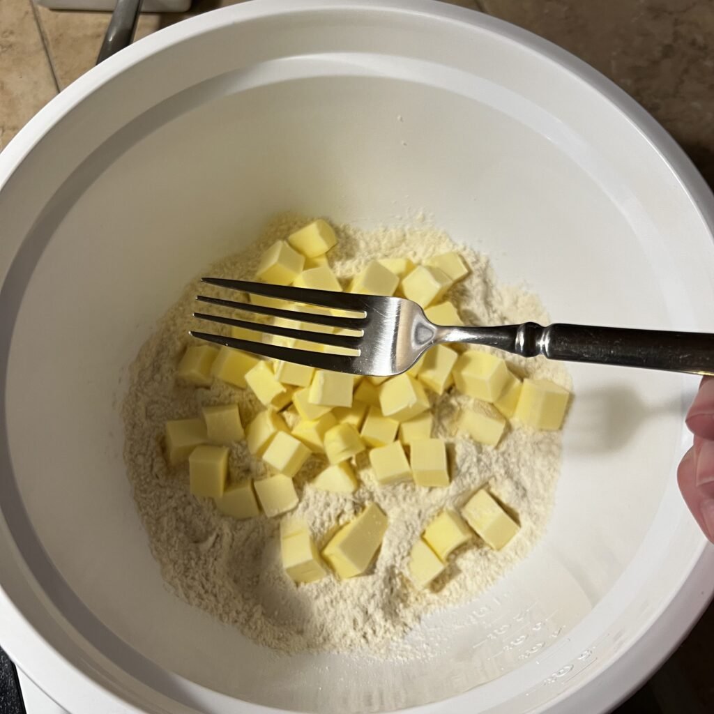 Using a fork to cut in the butter to make a buttery, flaky sourdough pie crust.