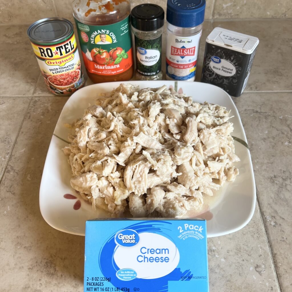 All of the ingredients needed to make creamy shredded chicken with Rotel and marinara sitting out on the counter ready to be cooked up.