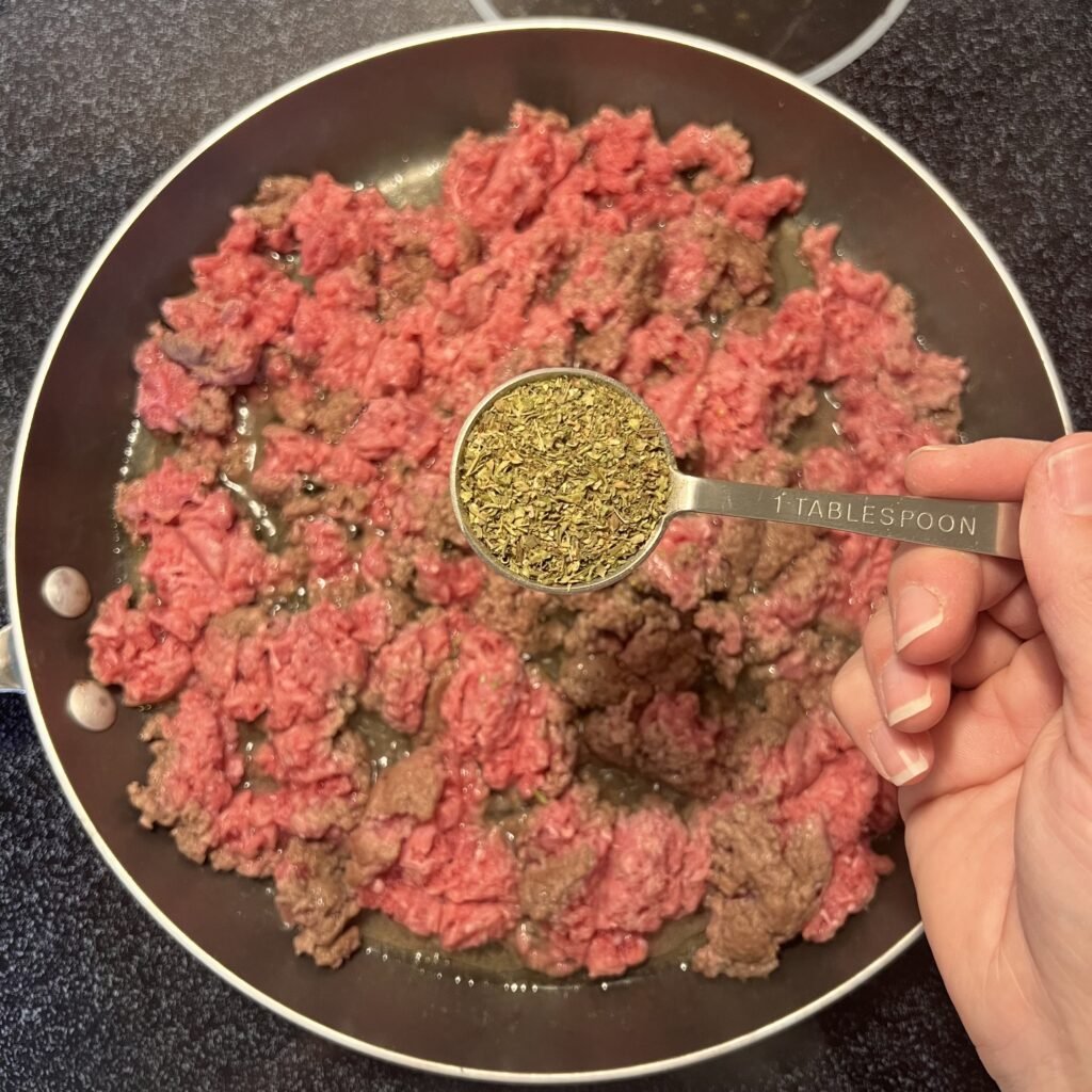 Overhead shot of a tablespoon of Italian seasoning mix for add flavor to your ground beef.