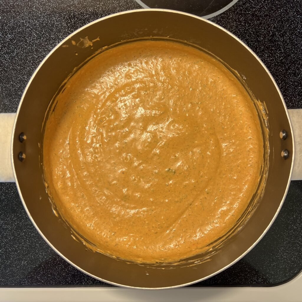 An overhead shot of a pot of marinara cream cheese sauce.