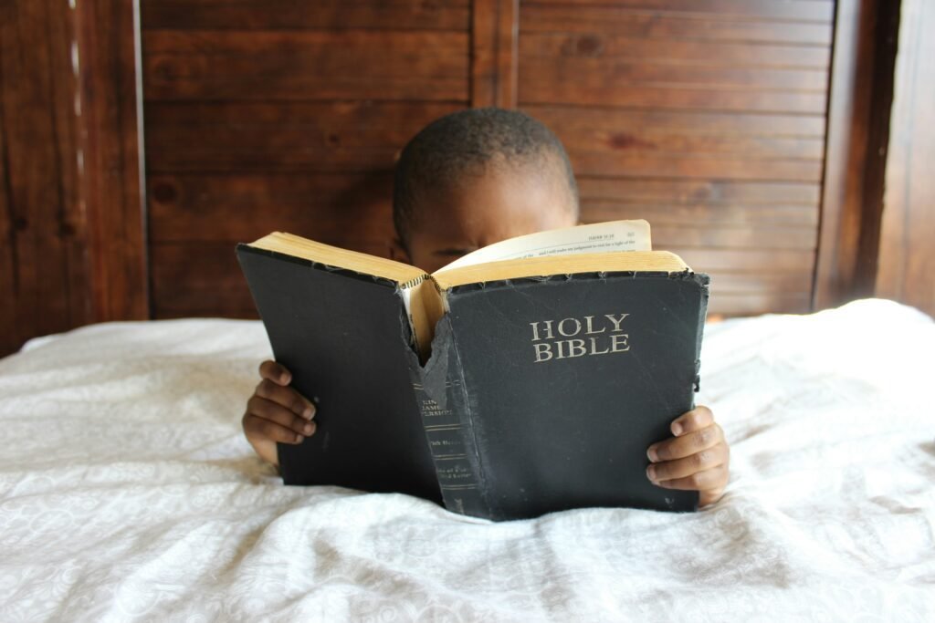 A young child reading the Bible.