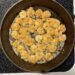 Sizzling low-carb fried shrimp cooking in a skillet on the stove.