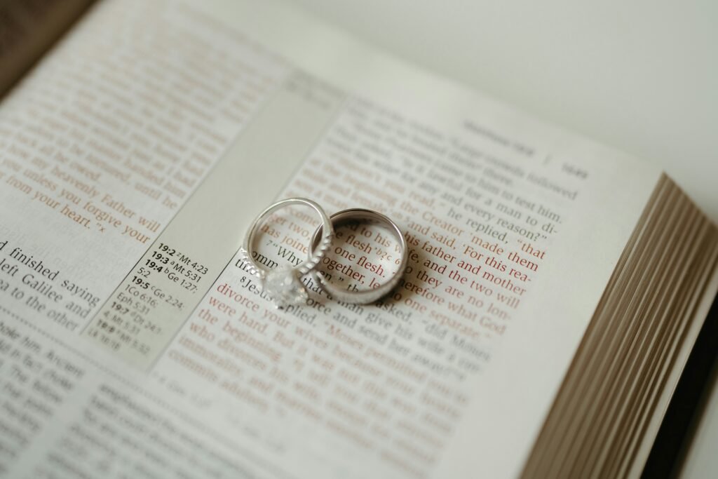 A close-up shot of wedding rings on the Bible. The background scripture is explaining God's design for marriage, between one man and one woman. It is a beautiful union where the two become one.