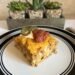 A side shot of a slice of delicious taco casserole topped with sour cream, jalapeños, and spicy salsa.