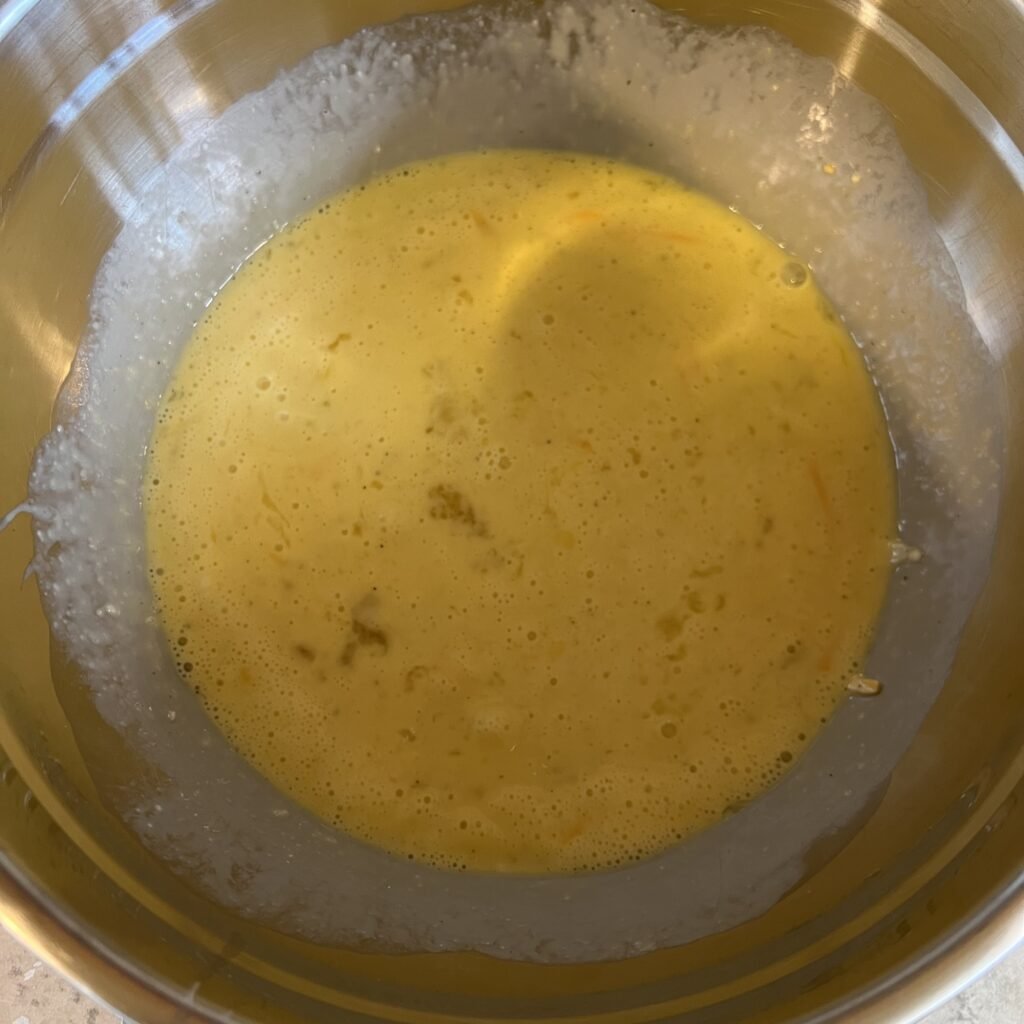 A close-up shot of the egg mixture in a bowl for the Keto Sausage and Egg Breakfast Casserole.