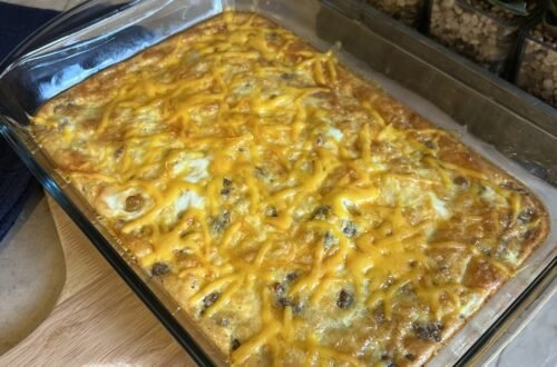 A side shot of a freshly baked keto breakfast casserole on the count with a blue towel and succulent plants in the background.