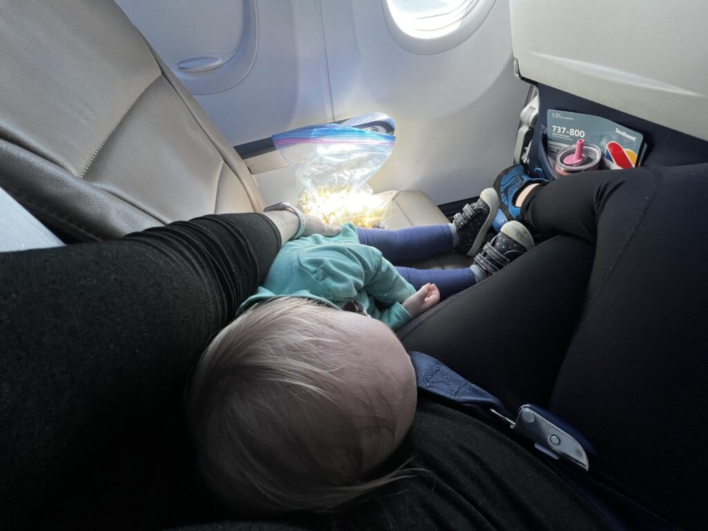Flying solo with a toddler can be very fun with these 7 packing and preparation tips. Pictured here is a mama and her toddler enjoying a flight to Denver.