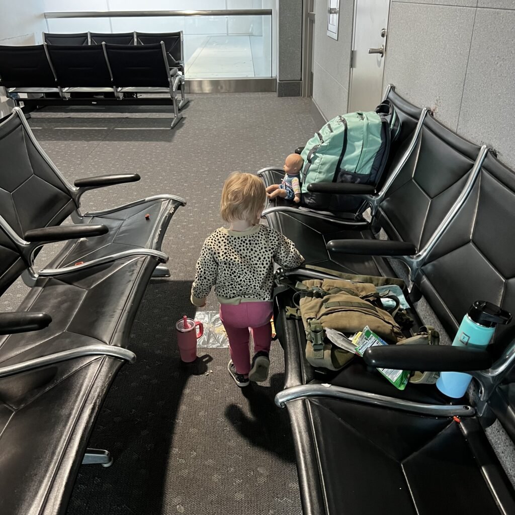 A mama and toddler resting space at the Denver airport, waiting to board their plane.