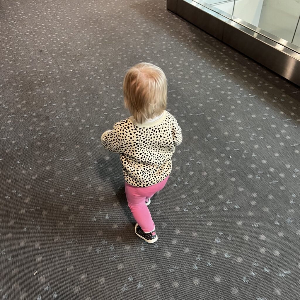 A cute toddler walking through the Denver airport.