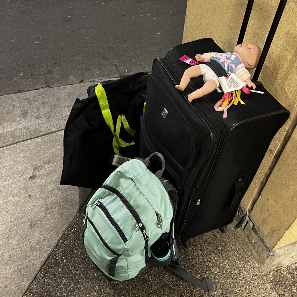 A mama and toddler's luggage sitting outside the MSP airport waiting for a shuttle.