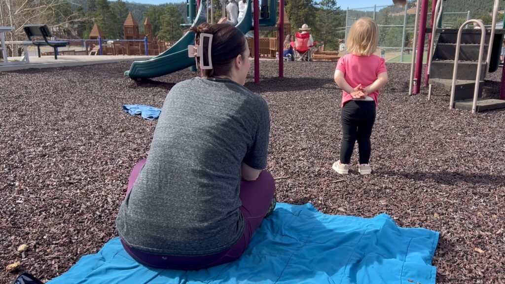 A mommy and toddler resting at the park.