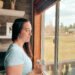 A busy mom standing by the window, finding rest in Jesus.